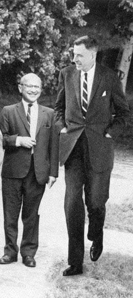 Milton Friedman y John Kenneth Galbraith caminando juntos por un patio.