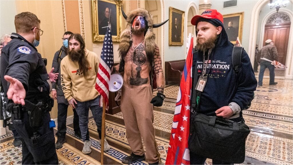 Hombre con cuernos y maquillado grita durante la toma del Capitolio de Estados Unidos en 2020, reclamando por la Presidencia de Donald Trump.