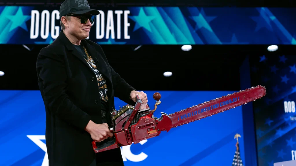 Elon Musk con una motosierra roja.