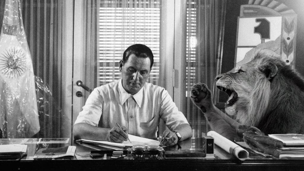 Juan Domingo Perón escribiendo en su escritorio. Al lado suyo, un león rugiendo.