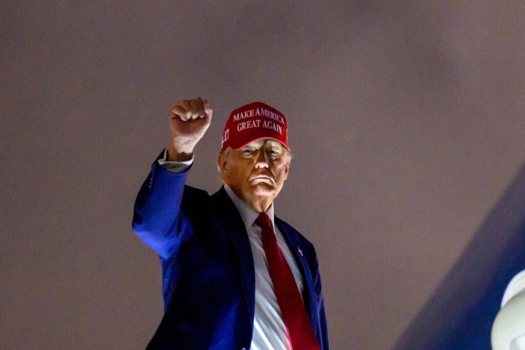 Donald Trump levanta puño. Tiene gorra de MAGA, Make America Great Again