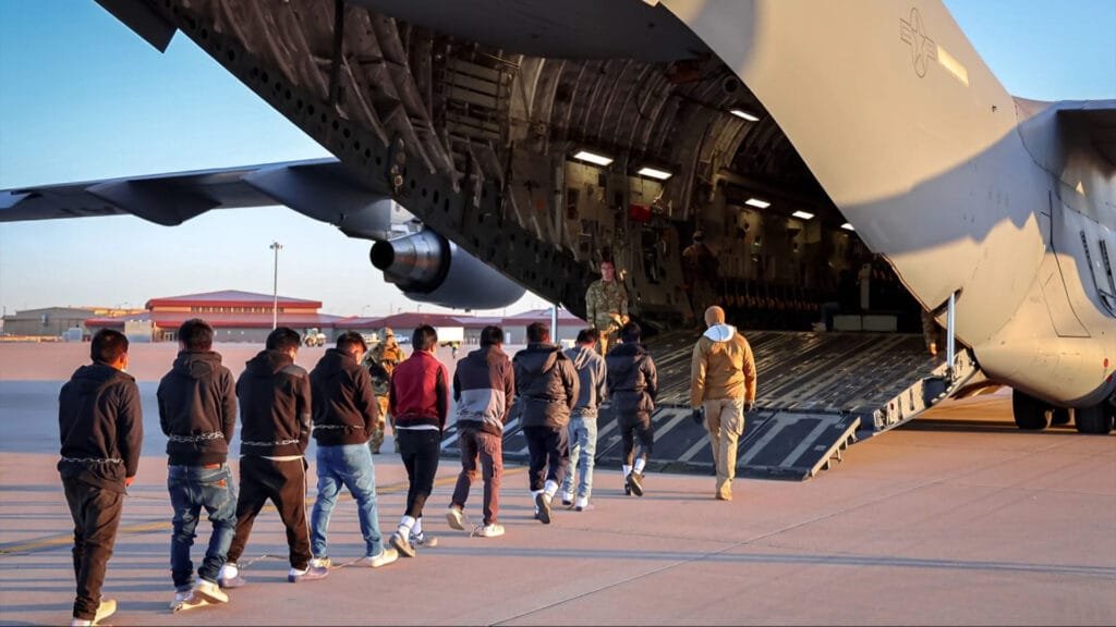 Fila de deportados de Estados Unidos subiendo a un avión militar