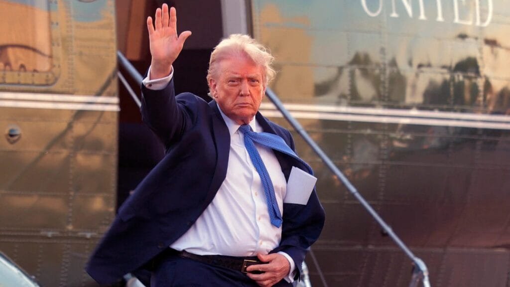 Donald Trump baja de un avión y saluda